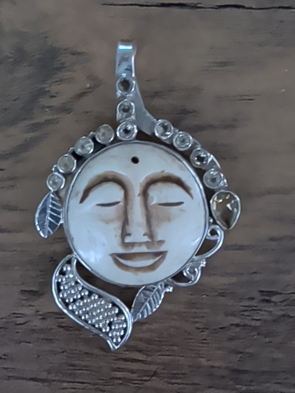 Sterling Silver pendant featuring a hand-carved face on mother-of-pearl
